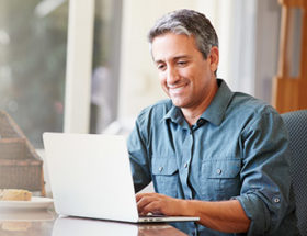 Man using his laptop to find a work life balance