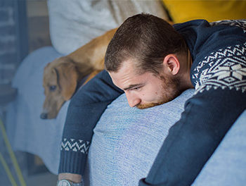 Emotional man on bed with sad dog
