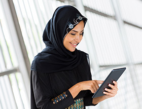 Beautiful Muslim woman in hijab using a tablet
