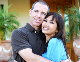 Beautiful Filipina woman hugging her Caucasian husband