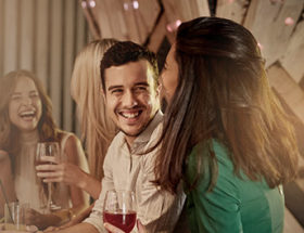 man chatting up an attractive woman in a bar