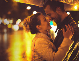 couple embracing in the rain under an umbrella