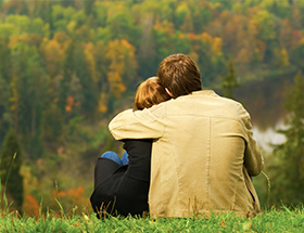 Couple hugging on a hill