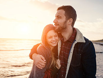 Couple hugging on a beach during sunset