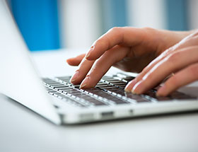 hands typing on a laptop