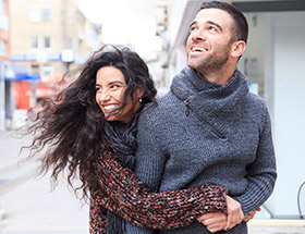 Couple in their 30s on a windy downtown street