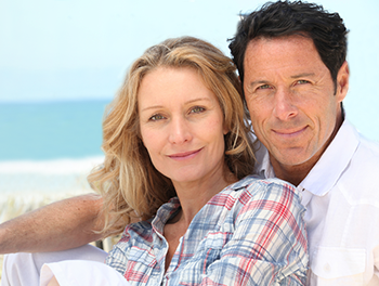 Couple in a cozy relationship stage hugging at the beach