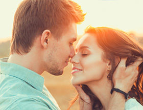 Connected couple kissing at sunset