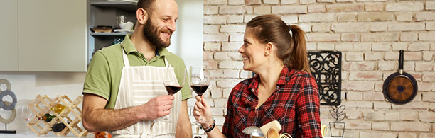 couple toasting each other in a kitchen