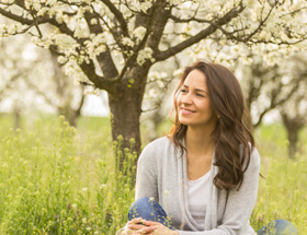Pretty woman admiring the blossom trees in a park