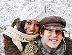 Happy black woman and white man in a winter park