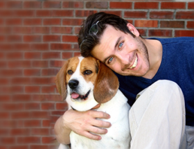 Handsome blue-eyed man hugging his pet dog