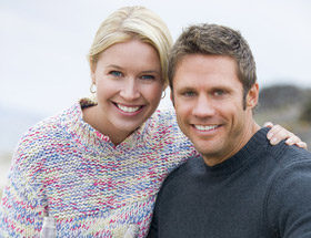 Smiling blonde couple on the beach