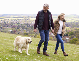 Mature couple taking a walk with their dog