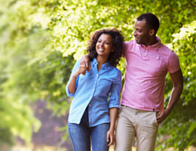 Couple strolling in the woods arm in arm